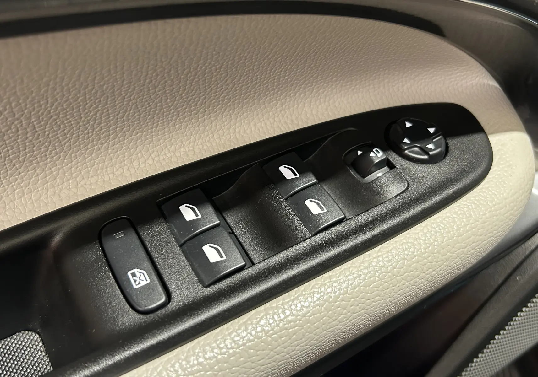 Gros plan sur les commandes de lève-vitres et réglages des rétroviseurs sur la porte beige d'une FIAT 600 Hybrid 2024.