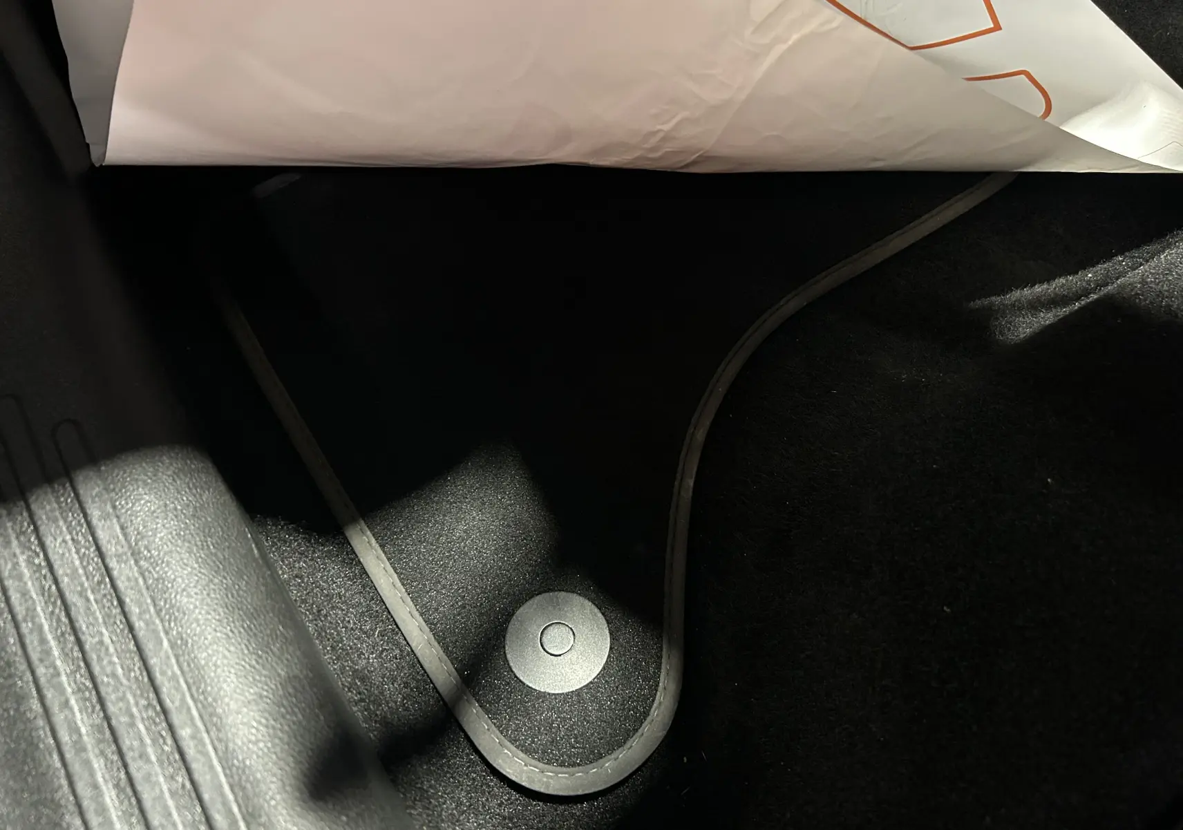 Détail du tapis de sol noir avec fixation circulaire dans l'habitacle d'une FIAT 600 Hybrid 2024 bleu.