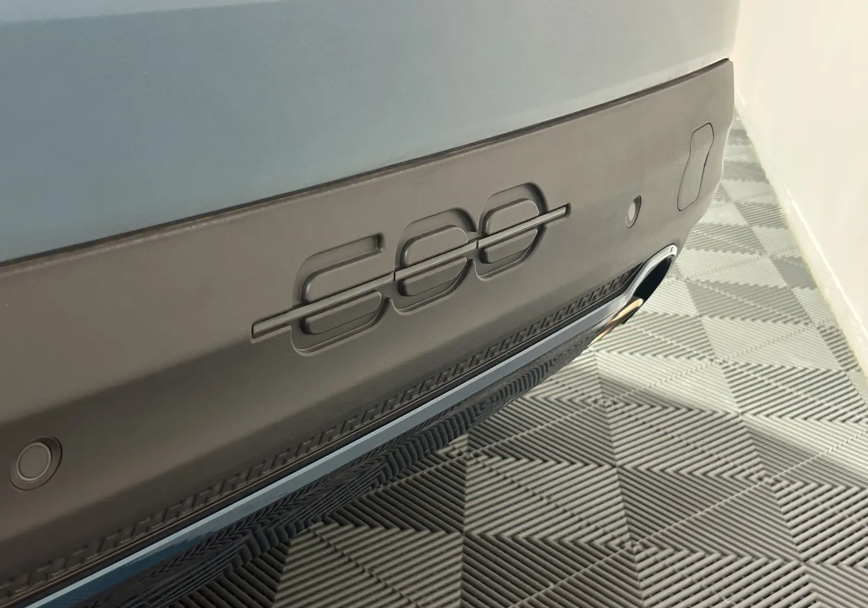 Gros plan sur le hayon arrière bleu de la FIAT 600 Hybrid 100 La Prima avec logo 600 embossé et sortie d’échappement visible.