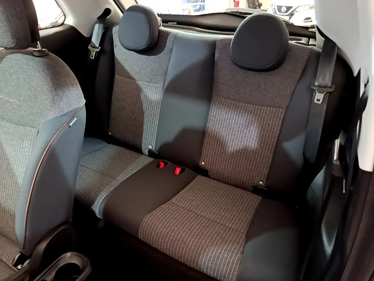 Vue intérieure arrière montrant la banquette grise à motifs rayés de la Fiat 500 42kWh Icône blanche 2022 électrique.