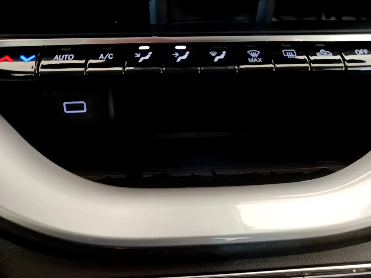 Gros plan sur les commandes de climatisation avec éclairage blanc, dans l'habitacle d'une FIAT 500 blanche Icône 2022 électrique.