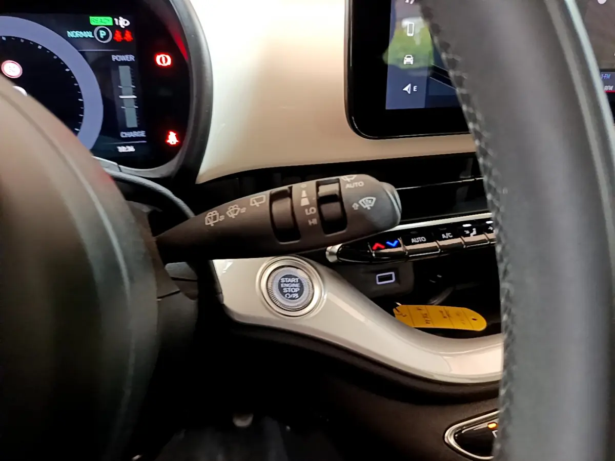 Détail du tableau de bord blanc et volant de la Fiat 500 électrique 42kWh Icône, avec bouton démarrage et commandes essuie-glaces.
