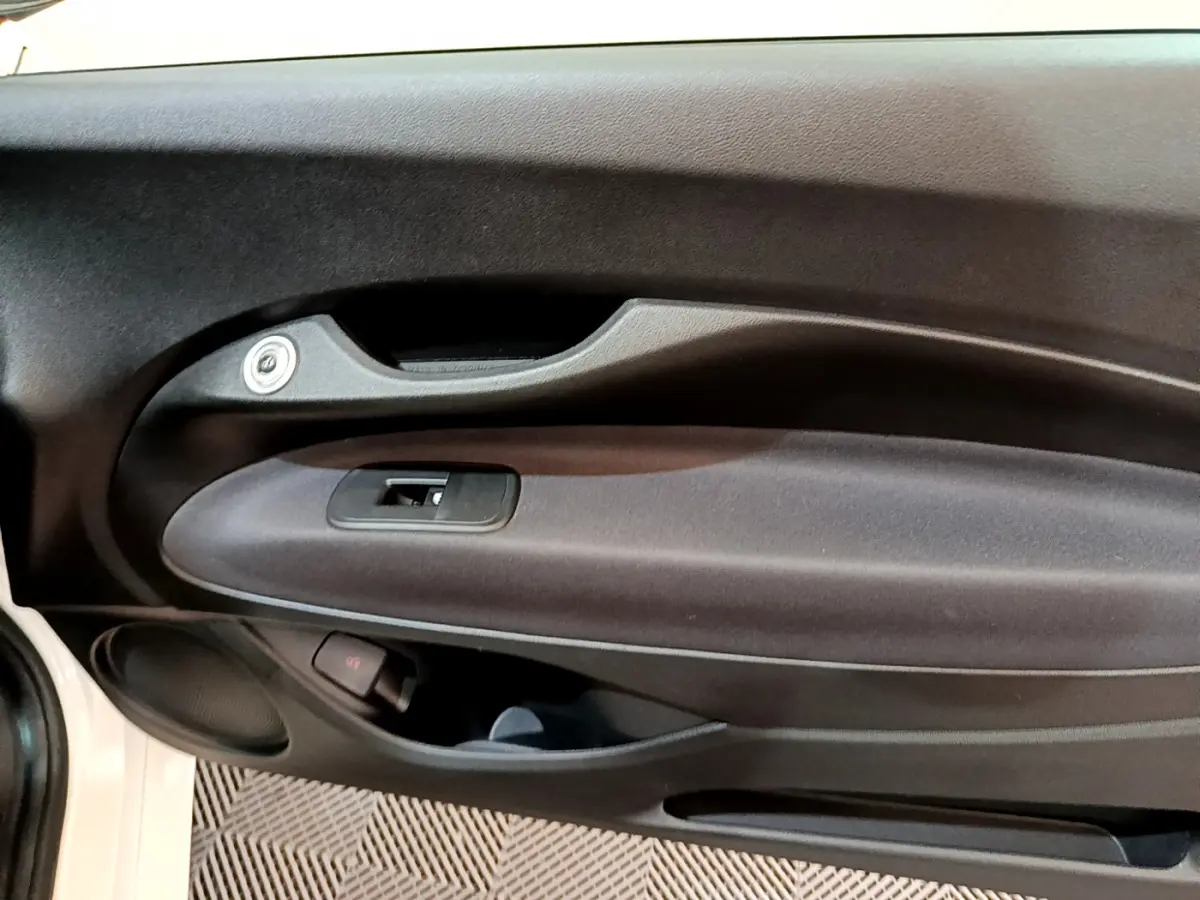 Gros plan sur la porte côté gauche blanche d'une FIAT 500 électrique 42kWh Icône, avec poignée et commande de vitre.