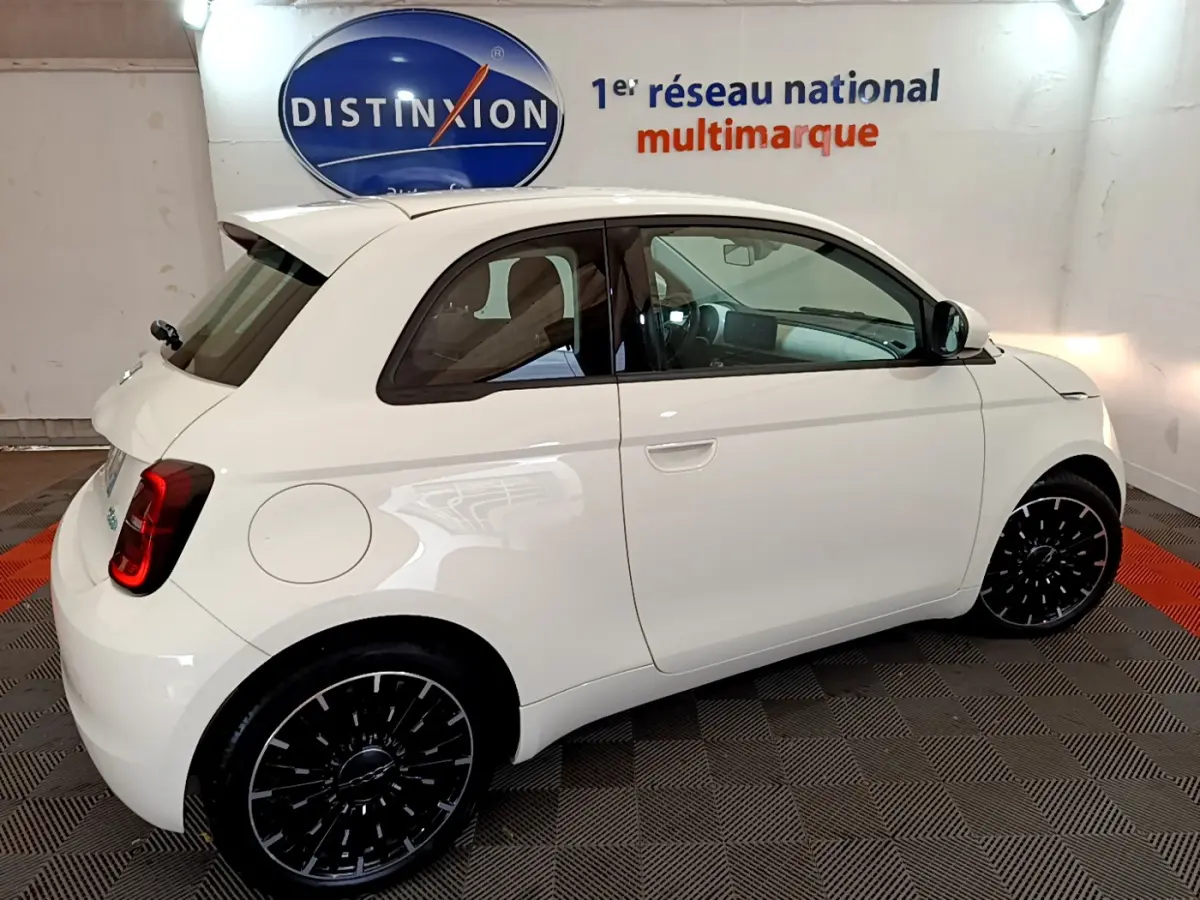 Profil droit de la Fiat 500 électrique blanche 42kWh Icône 2022, avec jantes noires et intérieur visible.