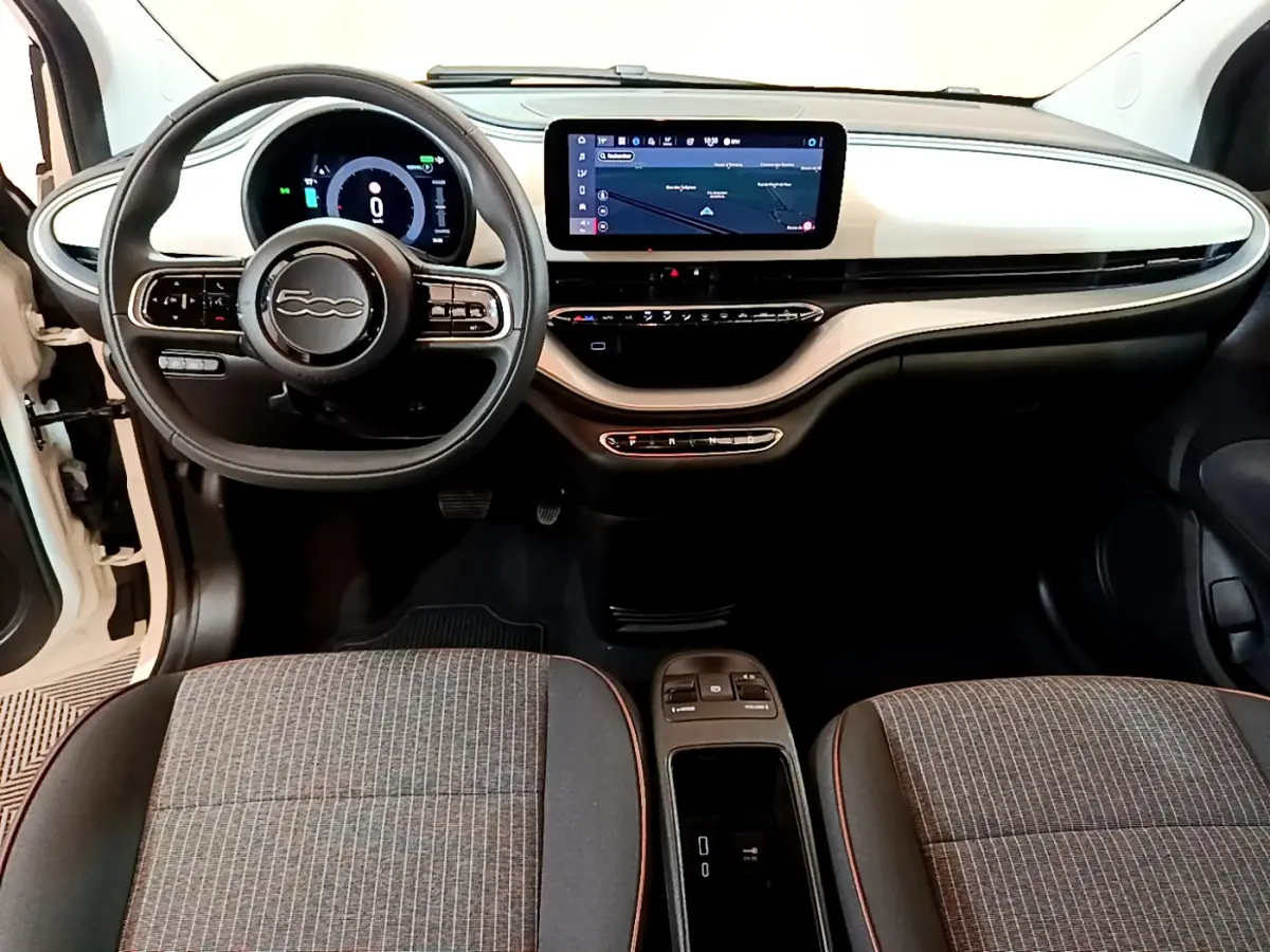 Intérieur de la Fiat 500 électrique 2022, vue frontale du tableau de bord blanc avec écran tactile et volant multifonctions.