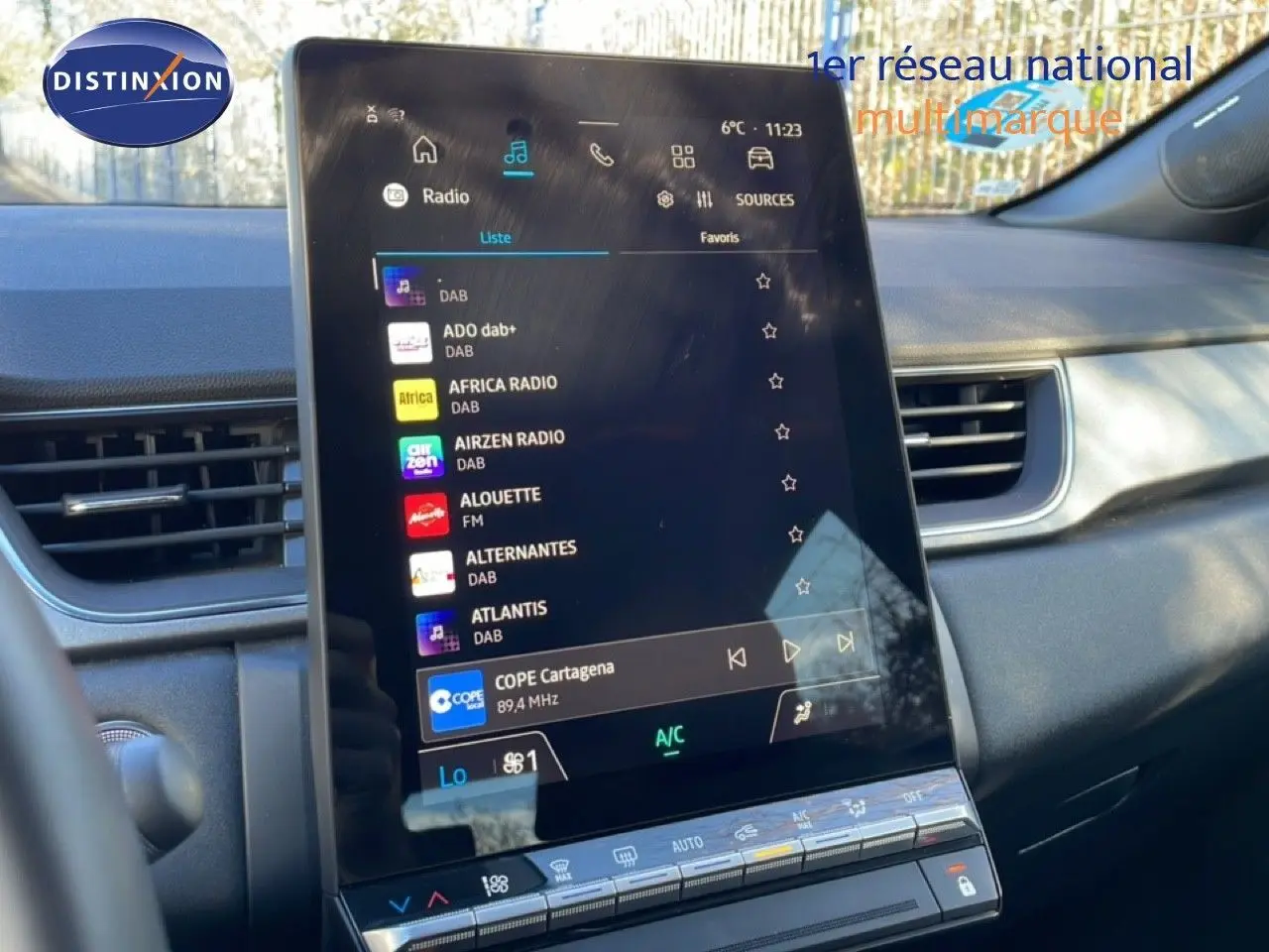 Vue intérieure centrée sur l'écran tactile du tableau de bord du Renault Captur 2025 avec radio numérique affichée.