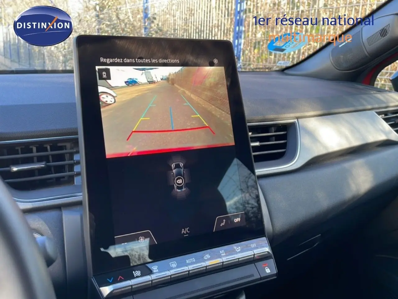 Vue intérieure centrée sur l'écran tactile affichant la caméra de recul du Renault Captur rouge Désir métal toit noir.