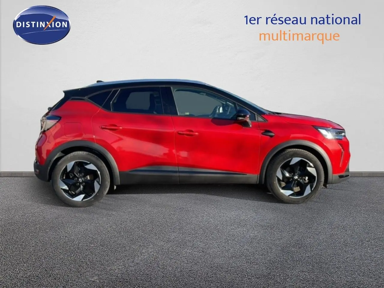 Profil droit d’un Renault Captur 2025 rouge désir métal avec toit noir, jantes noires et lignes modernes.