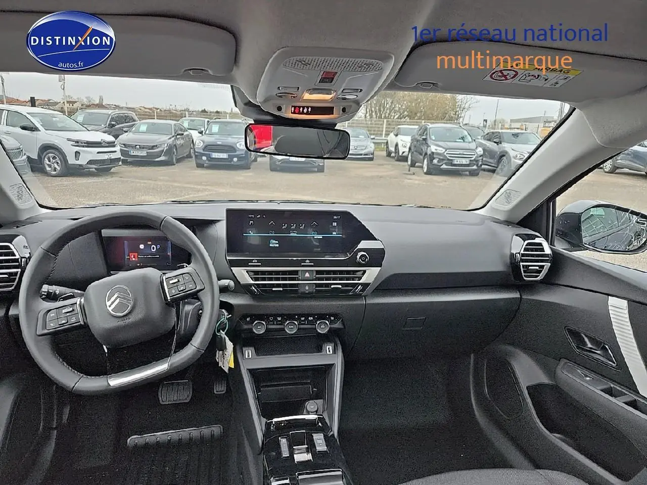 Vue intérieure avant de la Citroën C4 bleu eclipse, tableau de bord moderne avec écran tactile et volant multifonctions.