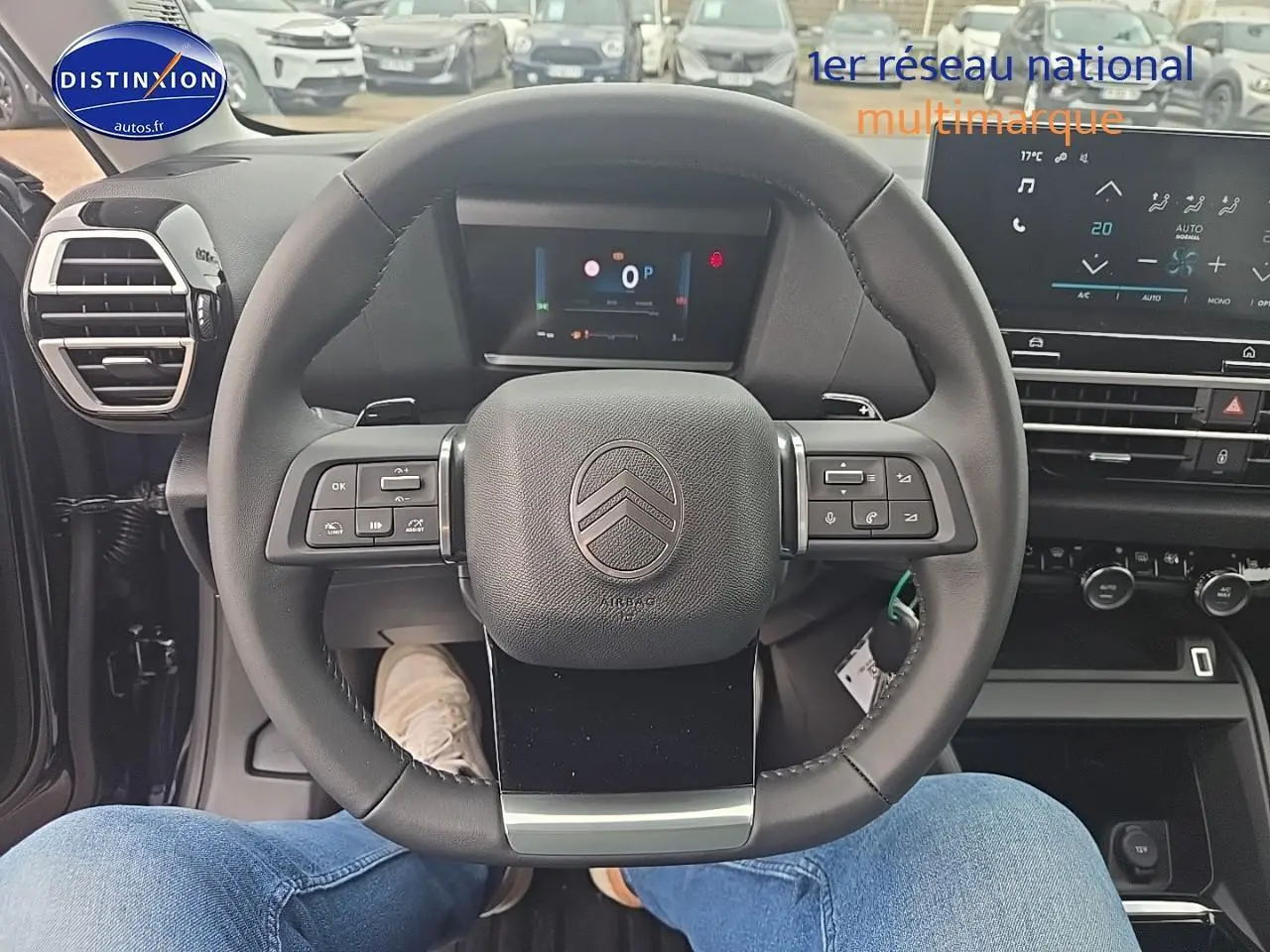 Vue intérieure centrée sur le volant cuir de la Citroën C4 bleu eclipse, avec tableau de bord numérique et écran tactile visible.