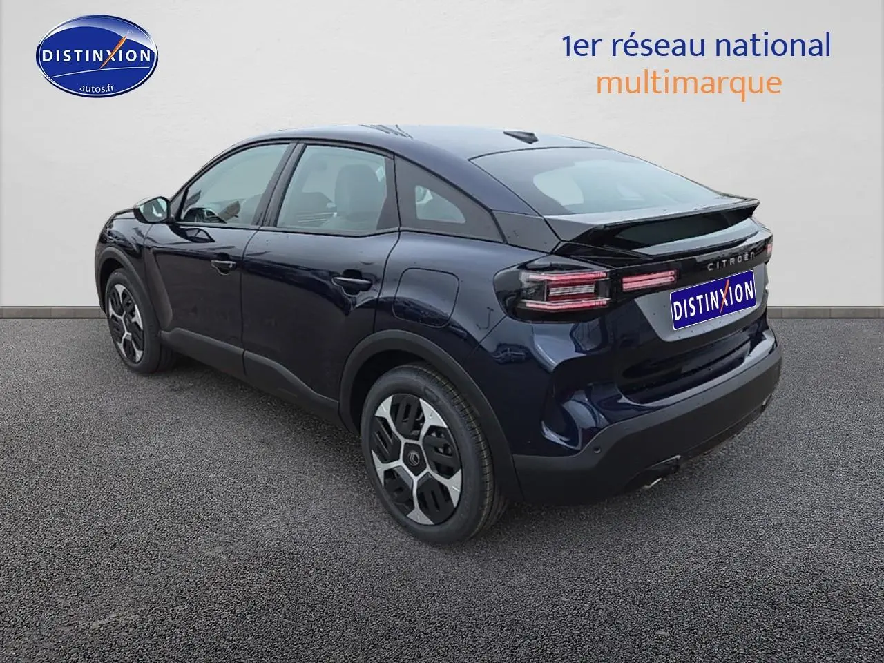 Vue 3/4 arrière droite d'une Citroën C4 1.2 hybride 145 plus bleu eclipse avec jantes 18 pouces et feux LED distinctifs.