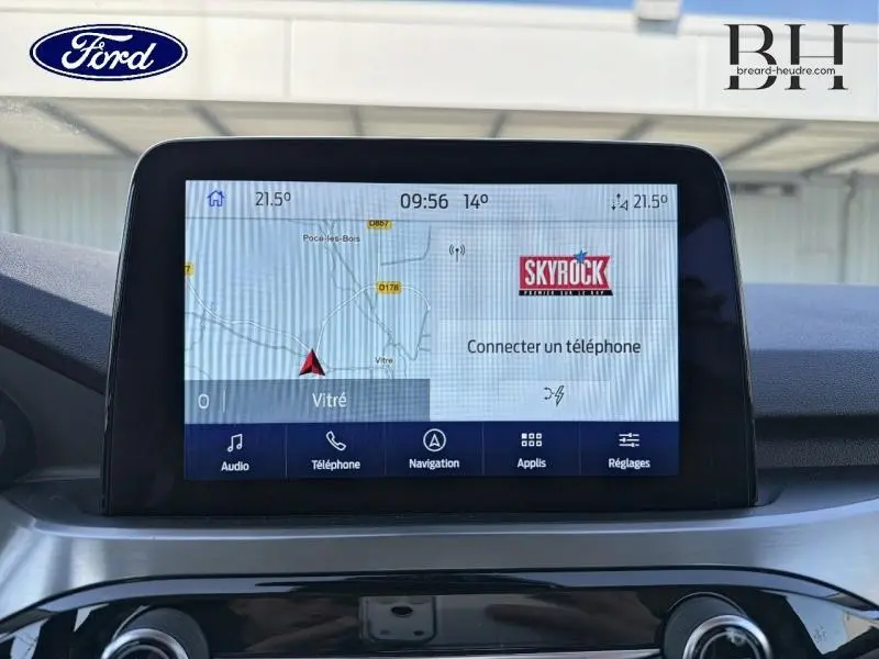 Écran tactile central du Ford Kuga 2023 affichant la navigation et la radio Skyrock, vue intérieure frontale.