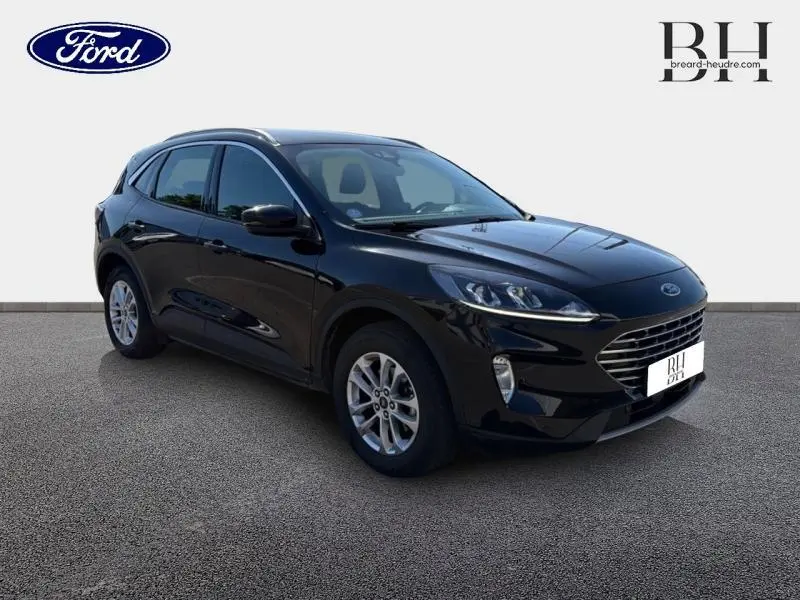 Ford Kuga 2023 noir Agate métallisé en 3/4 avant droit avec calandre large et jantes alu visibles.