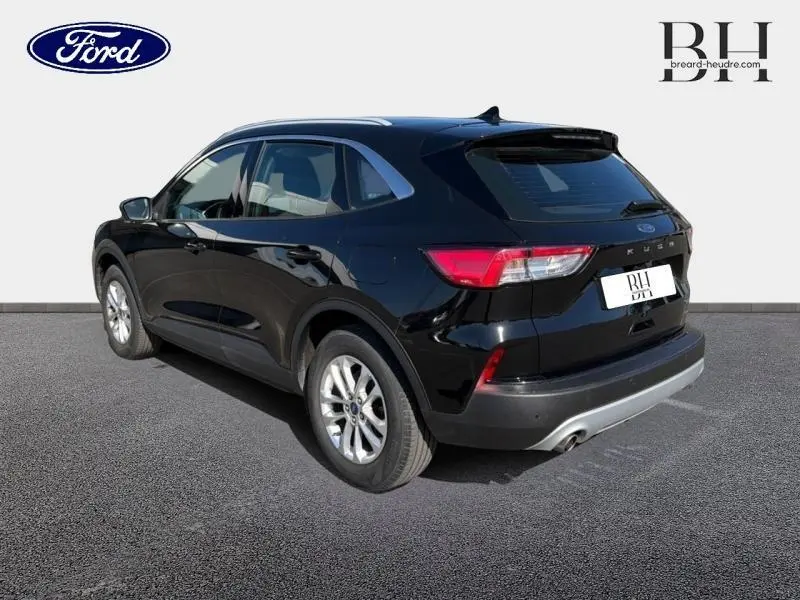 Ford Kuga noir agate métallisé vu en 3/4 arrière droit, avec jantes alu et feux arrière LED distinctifs.