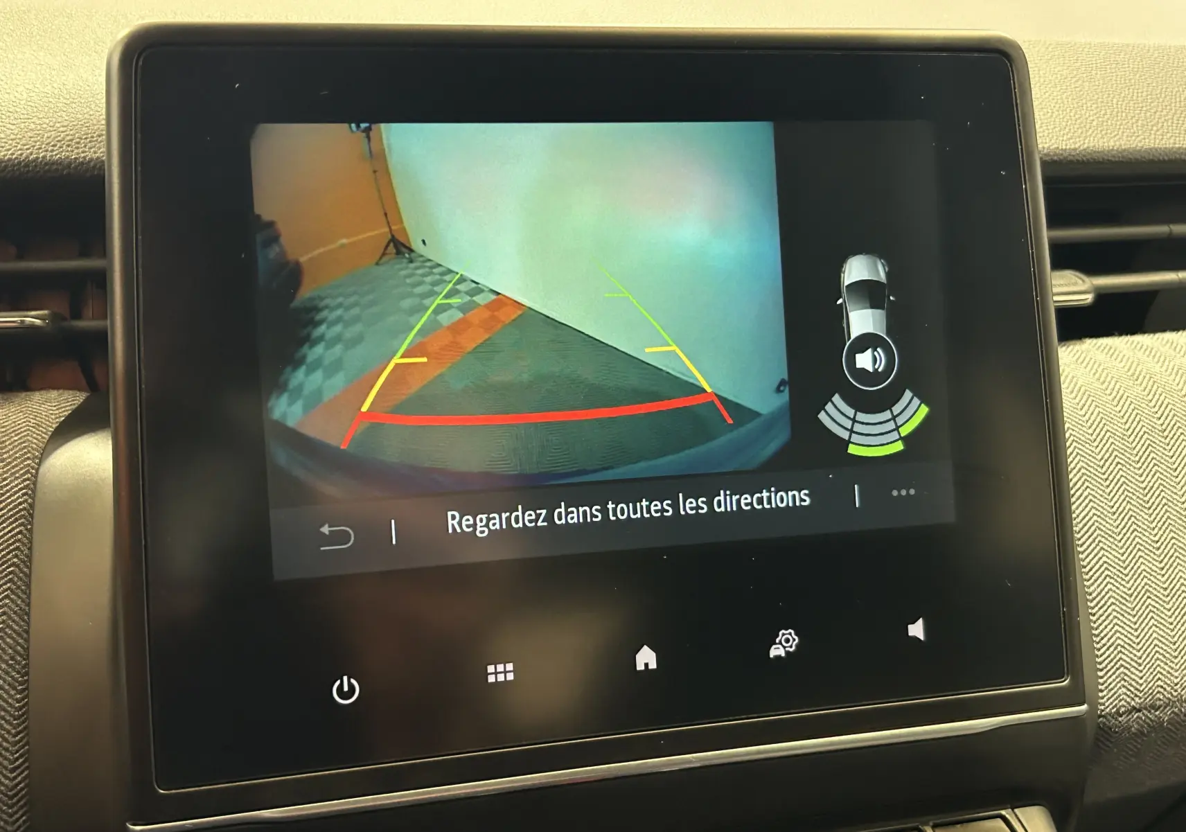 Écran central montrant la caméra de recul avec guidage coloré et alertes de proximité sur Renault Clio V.
