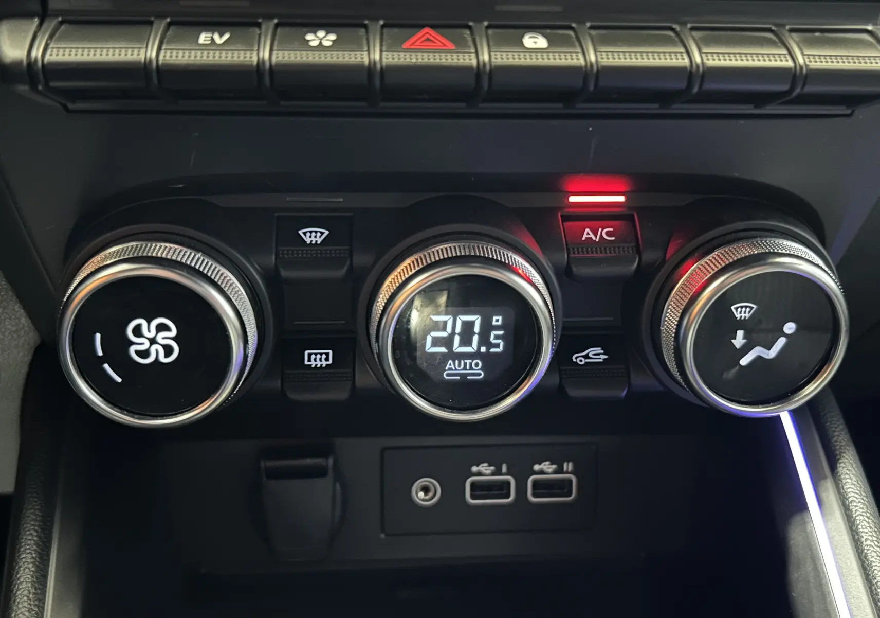 Gros plan sur les commandes de climatisation de la Renault Clio V, avec affichage digital et boutons rétroéclairés.