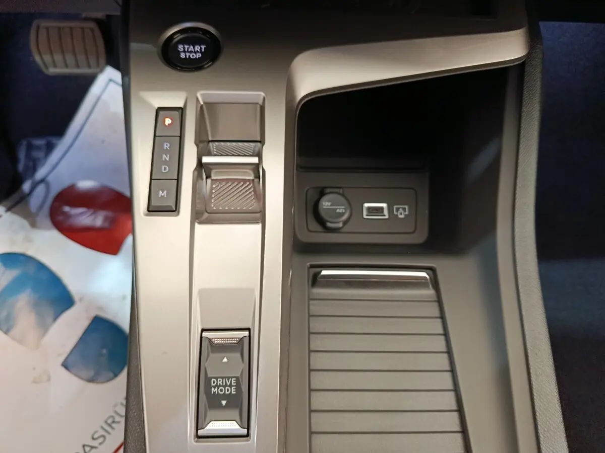 Vue rapprochée de la console centrale de la Peugeot 308 BlueHDi 130, avec sélecteur de boîte auto et prise 12V visible.
