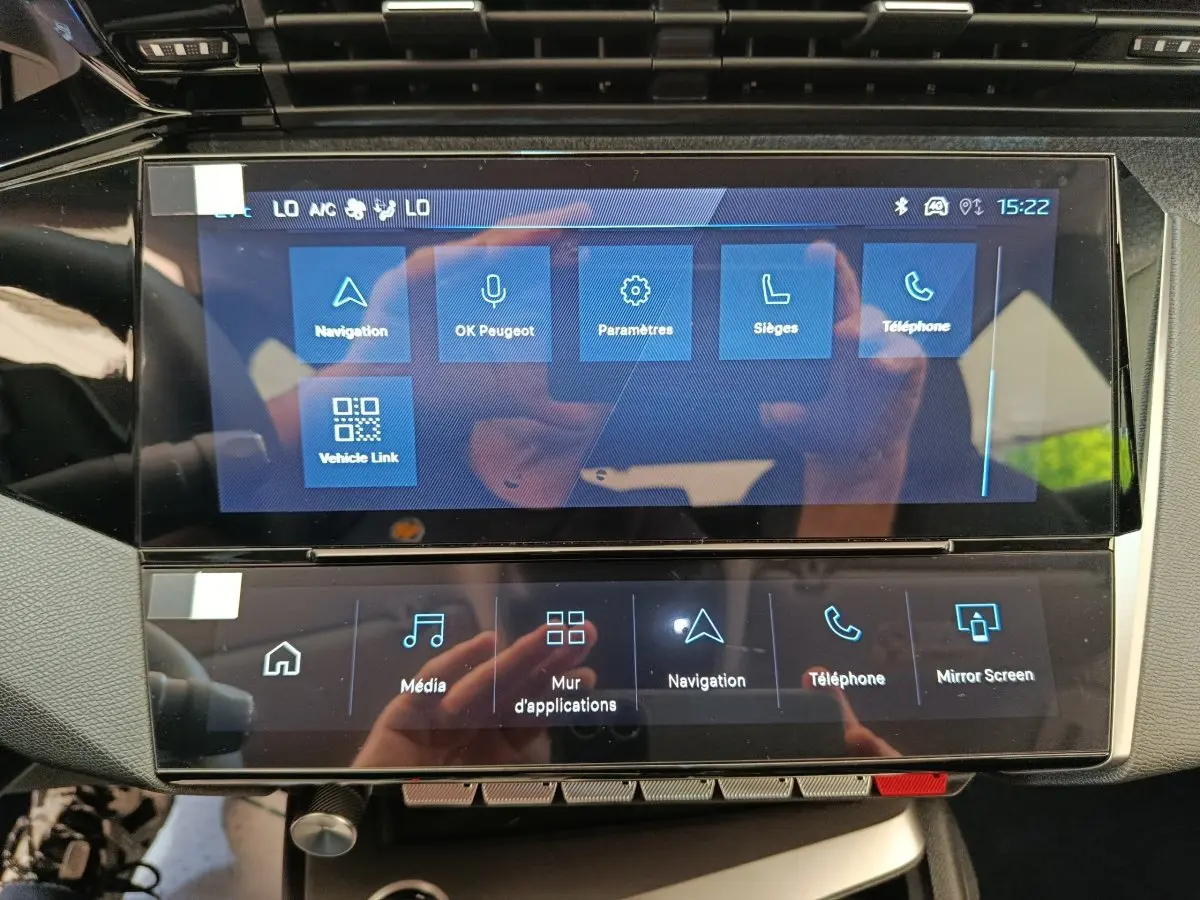 Écran tactile central du tableau de bord de la Peugeot 308 gris foncé, affichant les menus de navigation et téléphone.