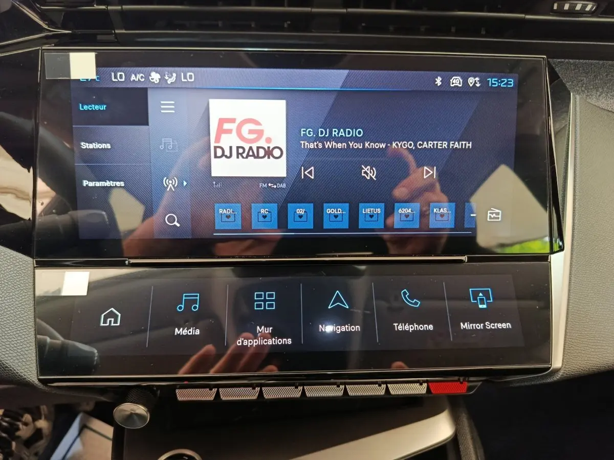 Écran tactile central de la Peugeot 308 2026 affichant la radio FG DJ Radio dans l'habitacle.
