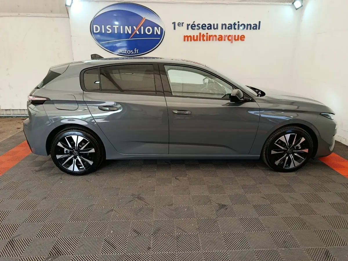 Profil droit de la Peugeot 308 BlueHDi 130 gris foncé 2026 avec jantes noires et détails chromés visibles.