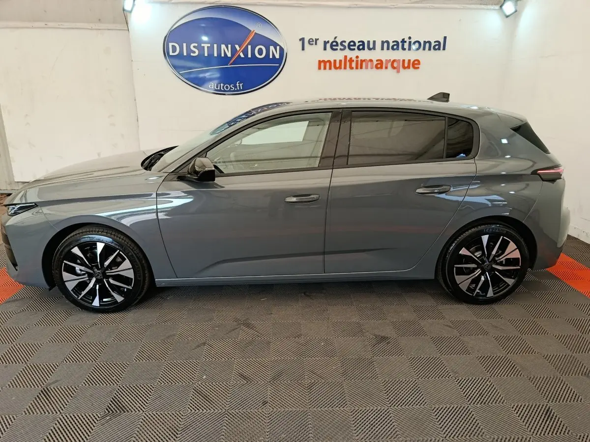 Peugeot 308 BlueHDi 130 gris foncé vue de profil côté gauche, jantes alliage noires et grises visibles.