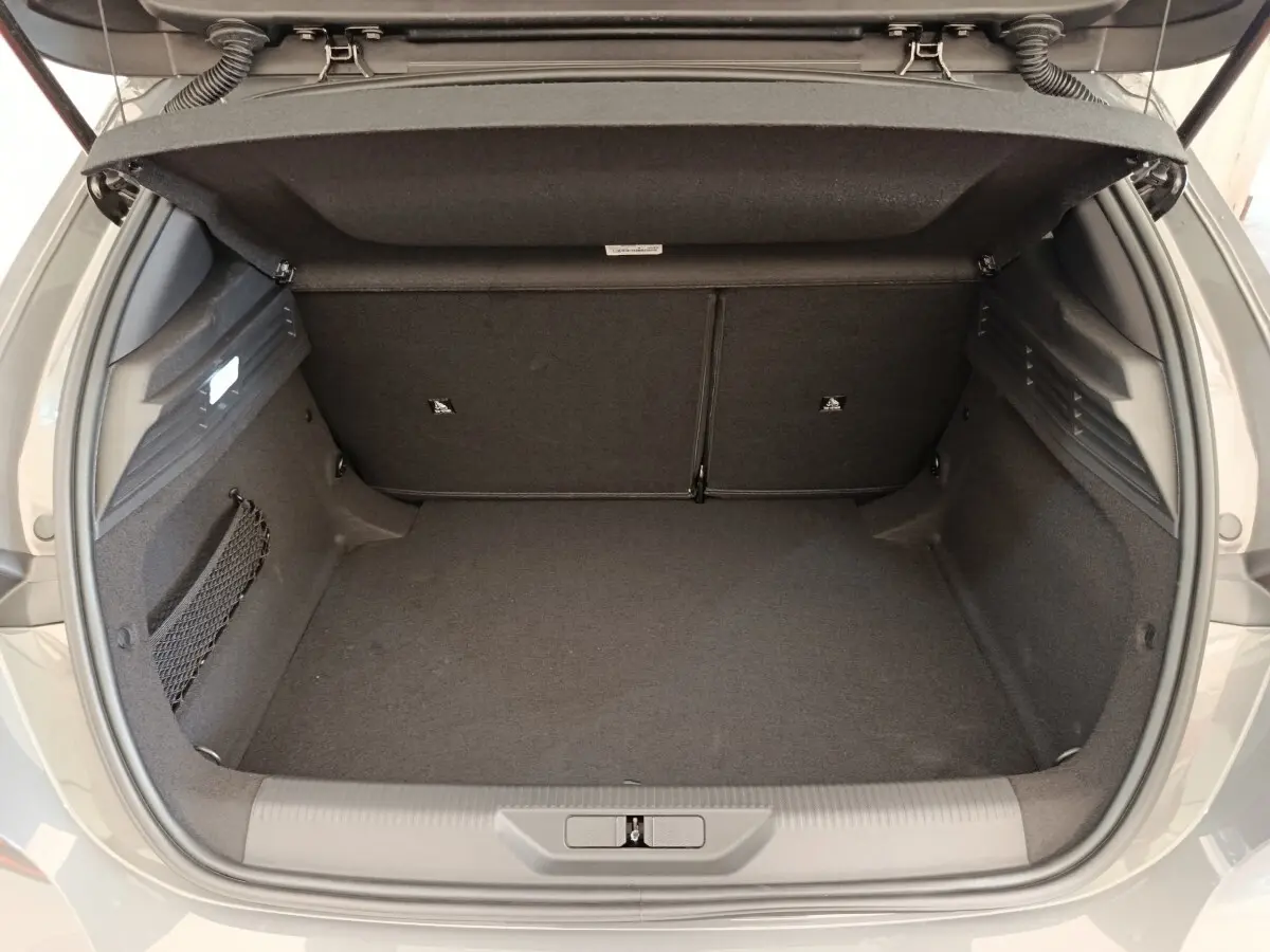 Coffre ouvert d’une Peugeot 308 gris foncé, vue arrière montrant l’espace de chargement et la banquette rabattable.