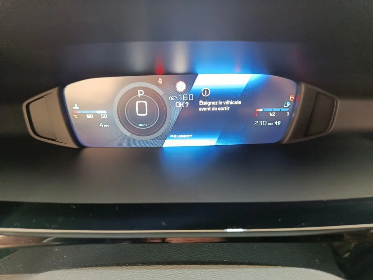 Affichage numérique du combiné instruments de la Peugeot 308 gris foncé, avec indication vitesse et alertes.