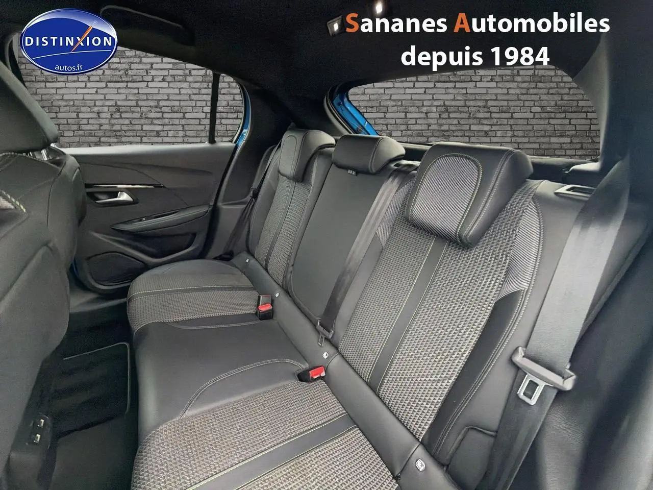 Vue intérieure arrière de la Peugeot 208 GT Line 2020, montrant la banquette noire avec surpiqûres vertes et ceintures de sécurité.