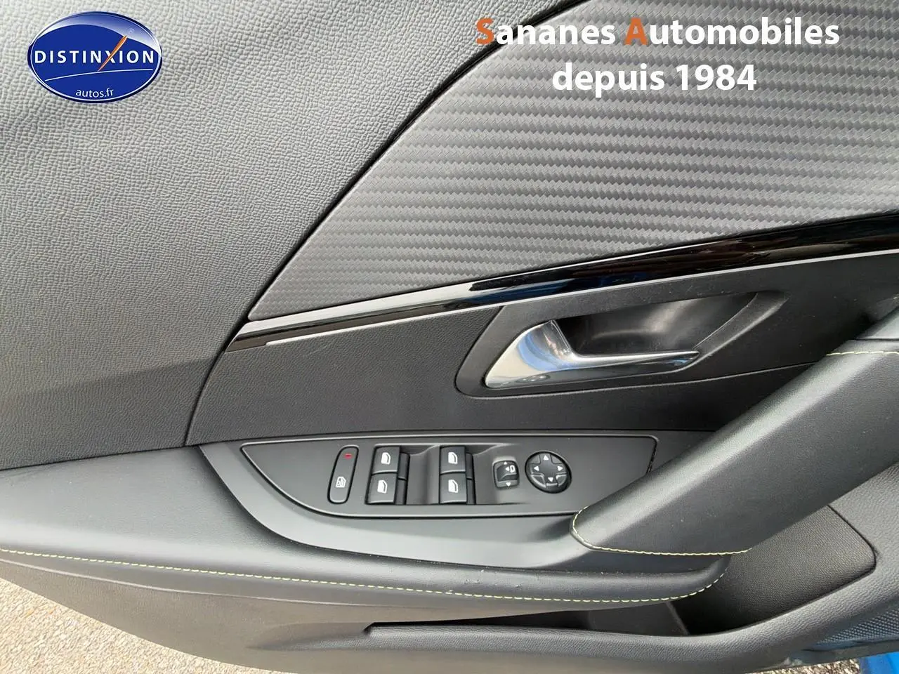 Gros plan sur la porte côté conducteur de la Peugeot 208 GT Line 2020 avec commandes des vitres et poignée noire.