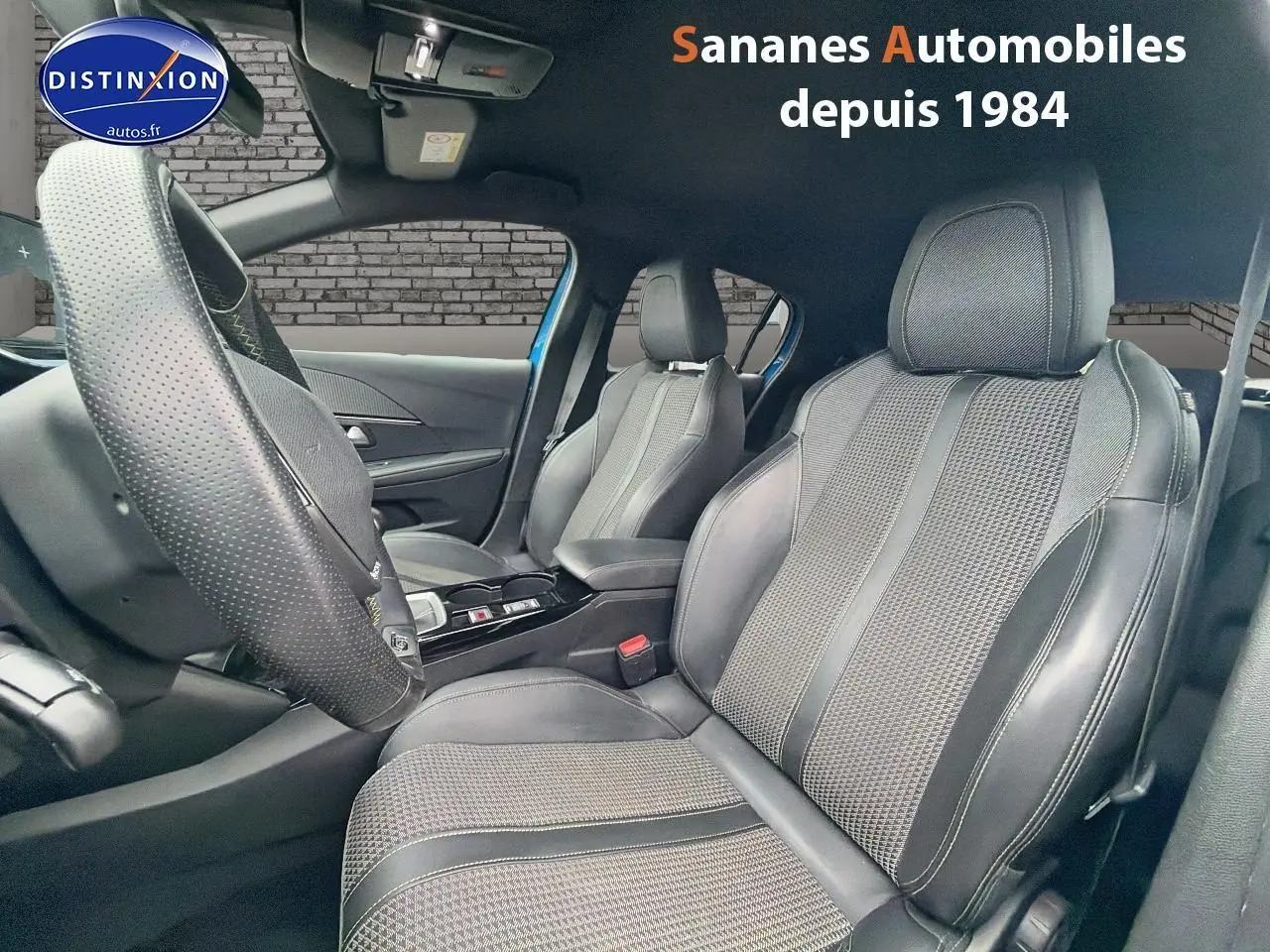 Vue intérieure côté conducteur de la Peugeot 208 GT Line 2020, sièges en tissu et cuir noir avec volant compact cuir.