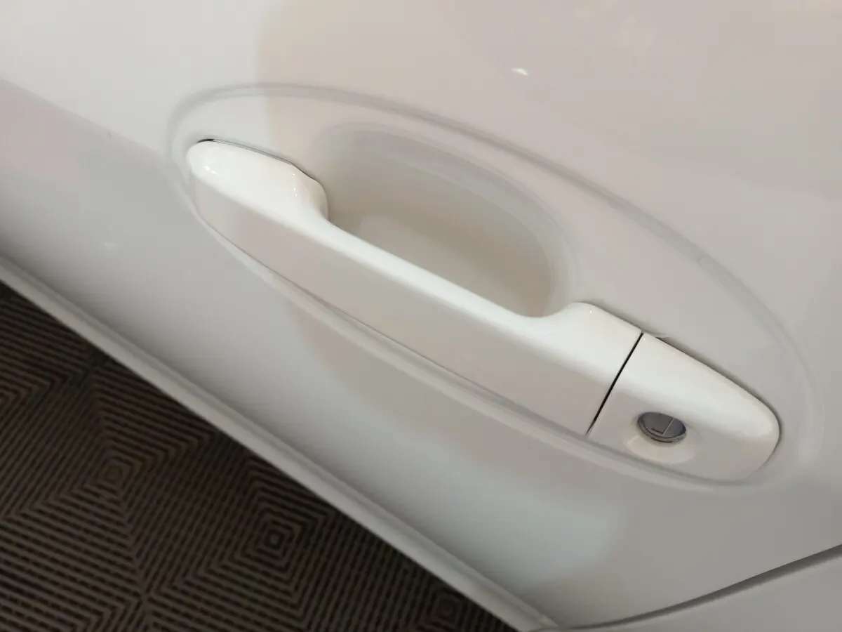 Poignée de porte blanche en gros plan côté gauche d'une Toyota Yaris hybride 2019 France Business.