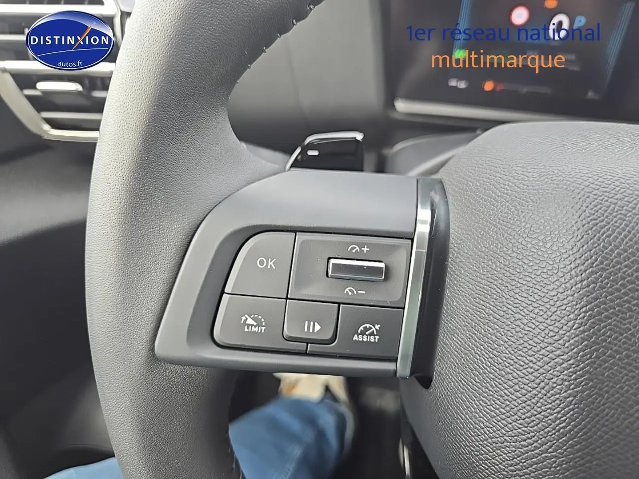 Gros plan sur les commandes au volant côté gauche du Citroën C4 blanc okenite, avec palettes de changement de vitesse.