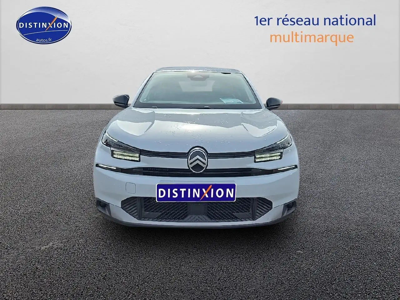 Vue frontale d'une Citroën C4 blanche Okenite avec signature lumineuse LED et calandre noire distinctive.