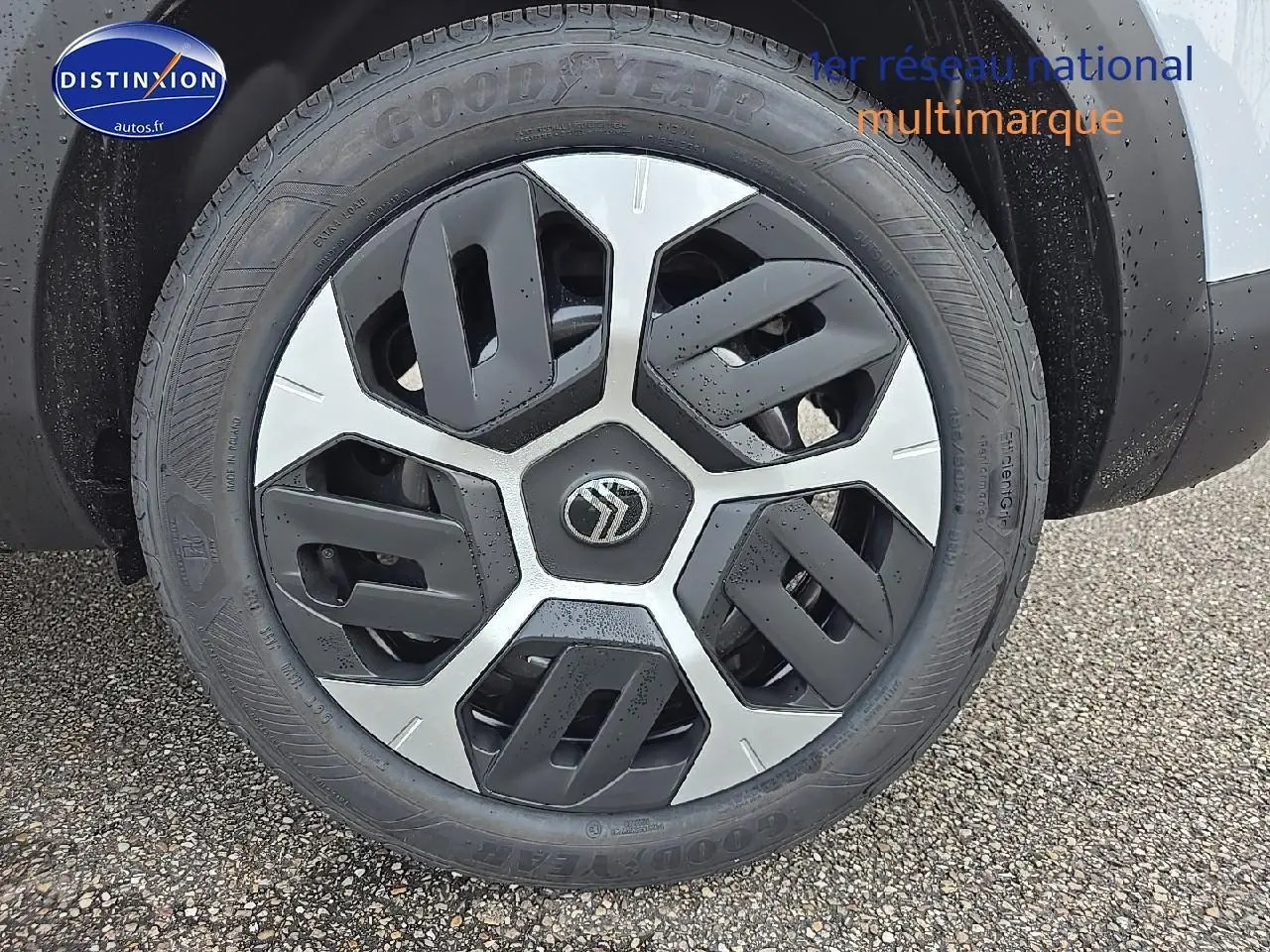 Gros plan sur la roue avant droite avec jante 18 pouces Aerotech noire et argentée d'une Citroën C4 blanc Okenite.