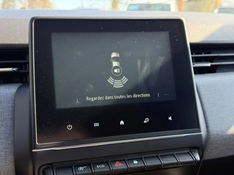 Écran tactile central de la Renault Clio gris schiste 2025 affichant une alerte de surveillance des alentours.