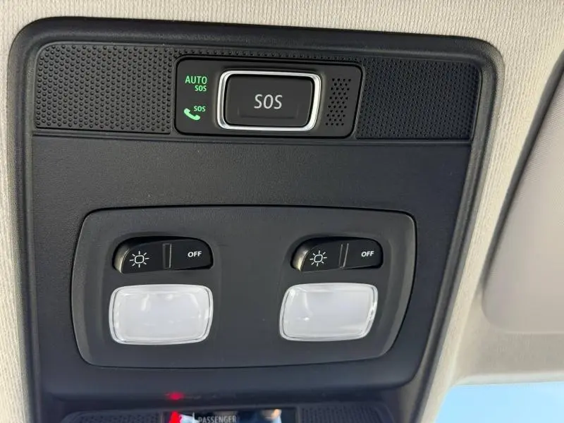 Gros plan sur la console de plafonnier noir avec bouton SOS et commandes d’éclairage intérieur de la Renault Clio gris schiste.
