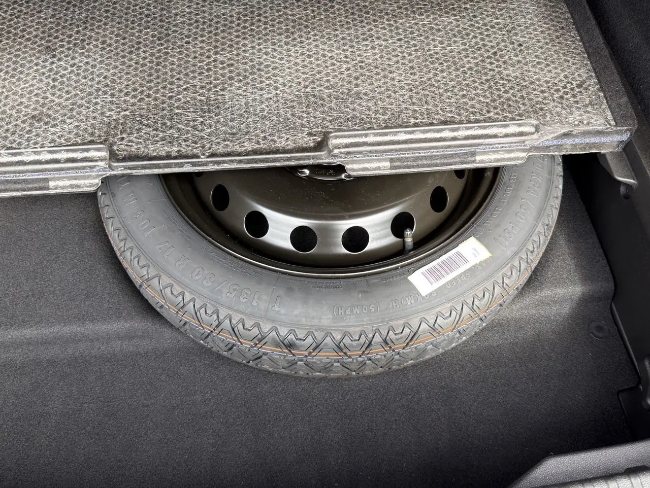 Gros plan sur la roue de secours sous le plancher du coffre d’une Renault Symbioz E-Tech Full Hybrid 2025.