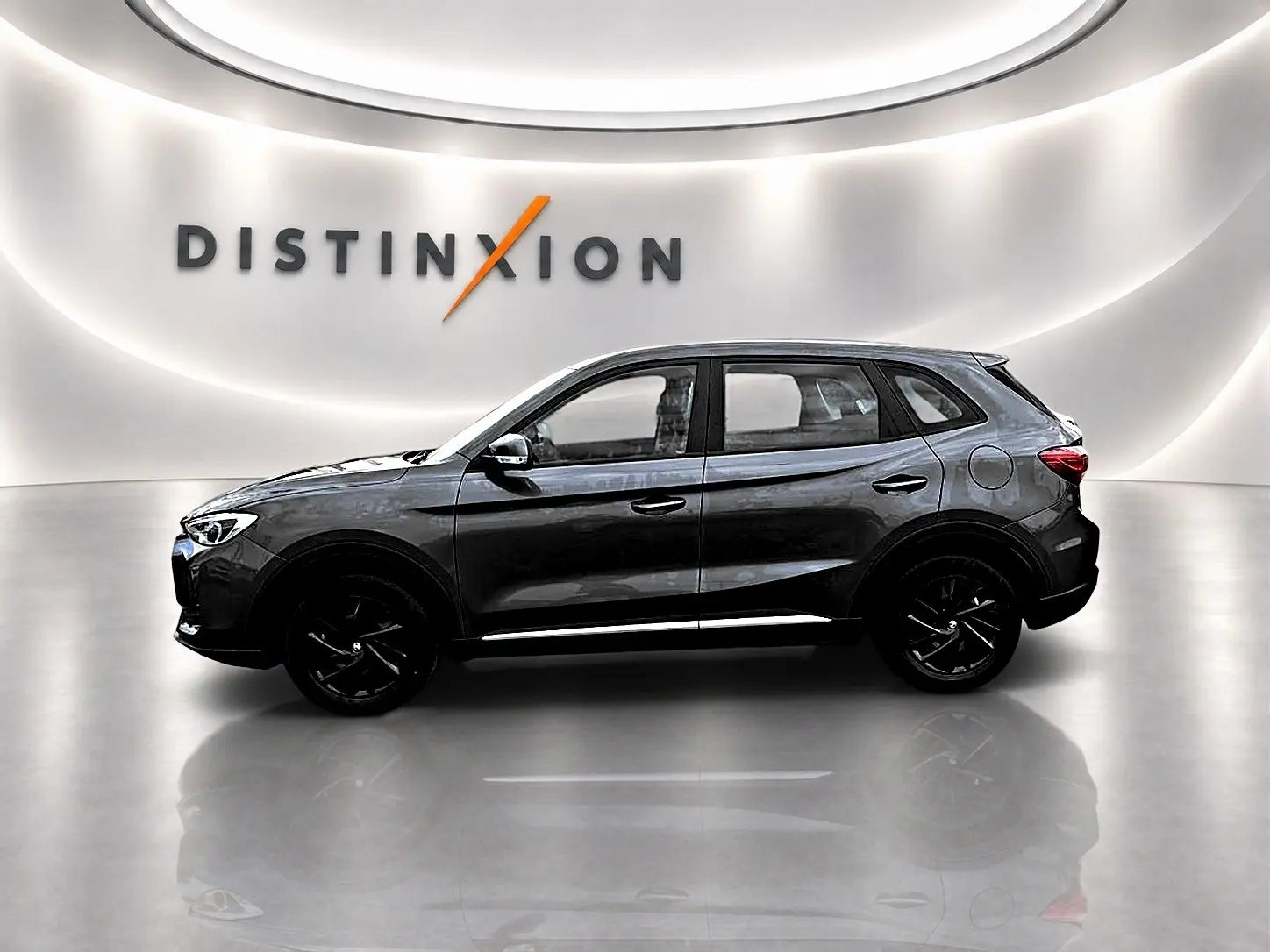 Vue de profil côté gauche du MG ZS Camden grey 1.5 hybrid 197 dans un showroom lumineux avec logo Distinxion en arrière-plan.