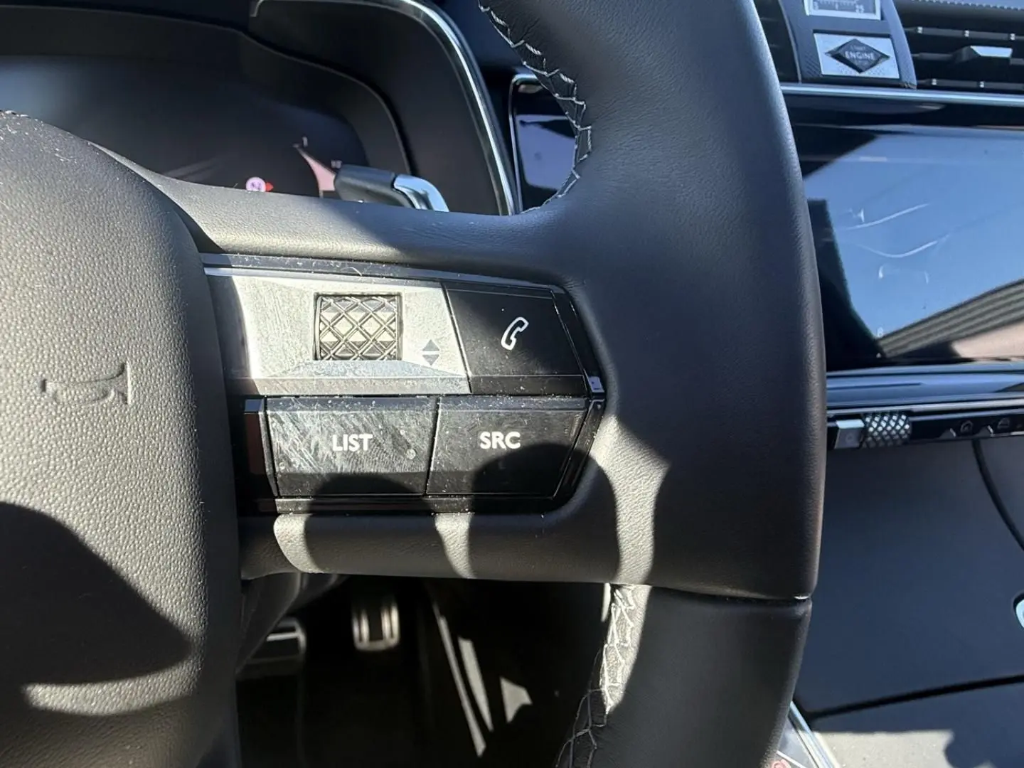 Détail du volant noir du DS7 2025 montrant les commandes intégrées côté gauche avec finition cuir et coutures apparentes.