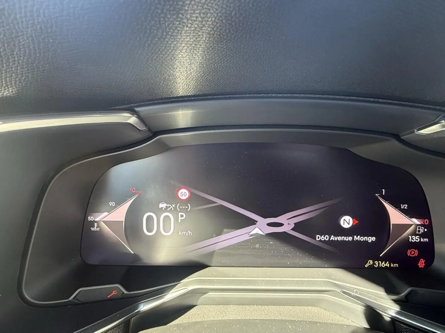 Vue rapprochée du tableau de bord numérique du DS7 2025 gris métal, affichant la vitesse à 0 km/h et la navigation active.