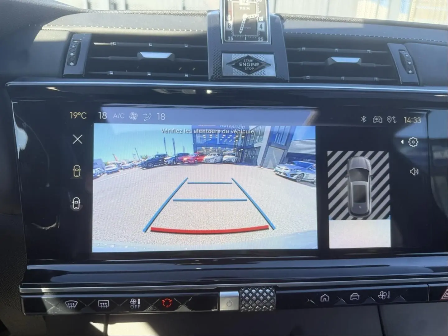 Écran central du DS7 1.5 HDI 130cv 2025 montrant la caméra de recul avec vue arrière sur un parking en extérieur.