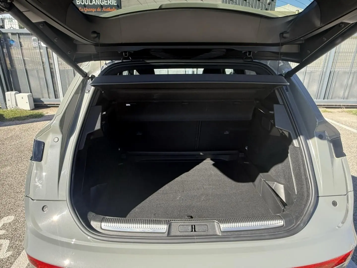 Coffre ouvert vu de l'arrière d'un DS7 1.5 HDI gris métal 2025, montrant un espace de chargement spacieux et propre.