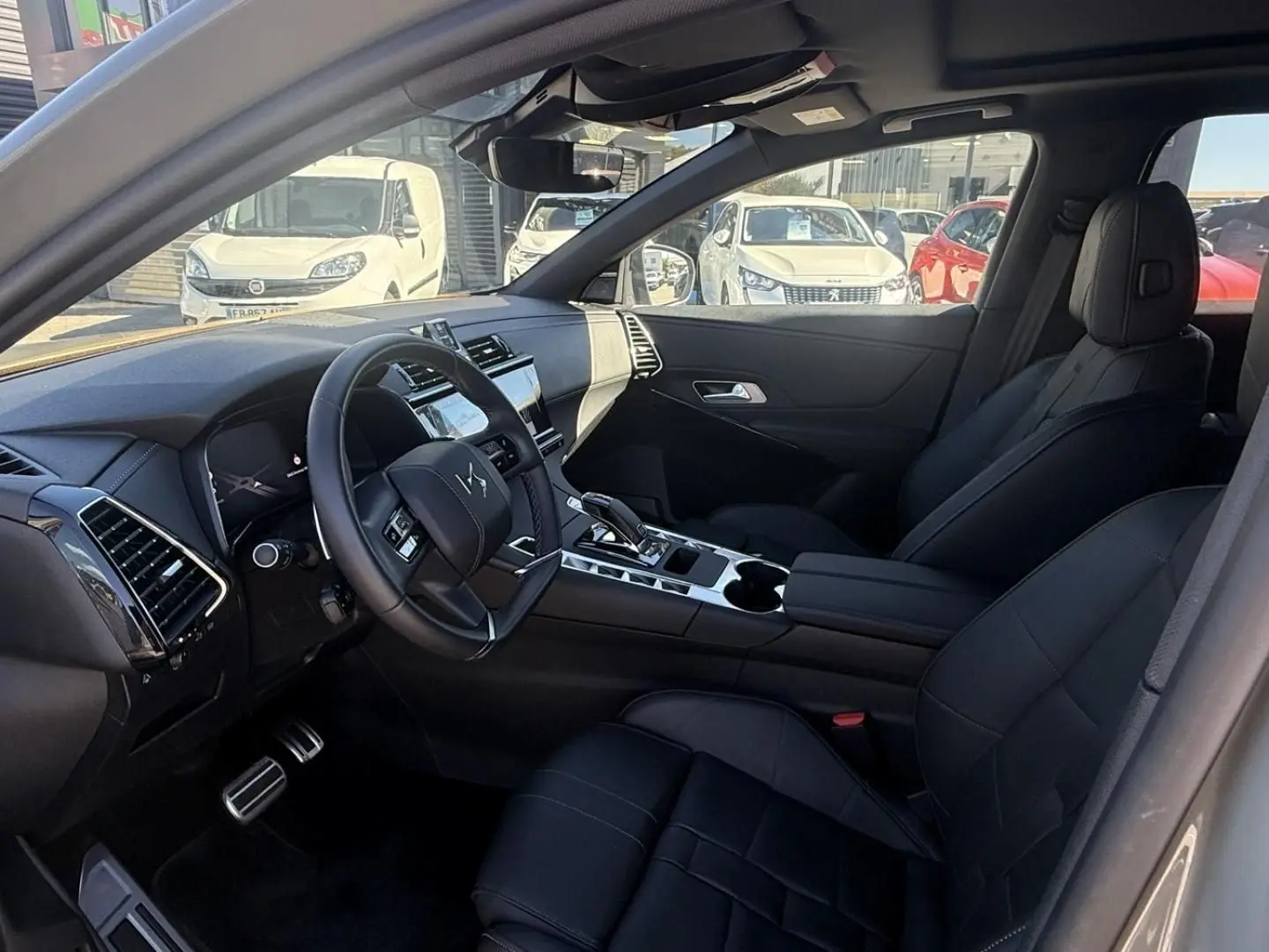 Intérieur du DS7 1.5 HDI 130cv Etoile 2025 en gris métal, vue côté conducteur montrant tableau de bord et sièges noirs cuir.