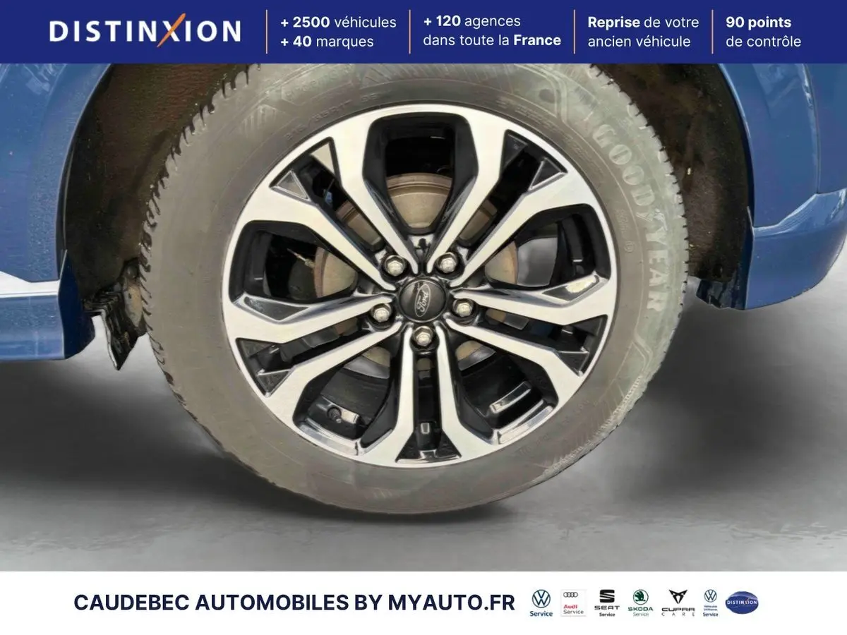 Gros plan sur la jante alliage 17 pouces noire et argent du Ford Puma bleu, avec partie d'aile visible.