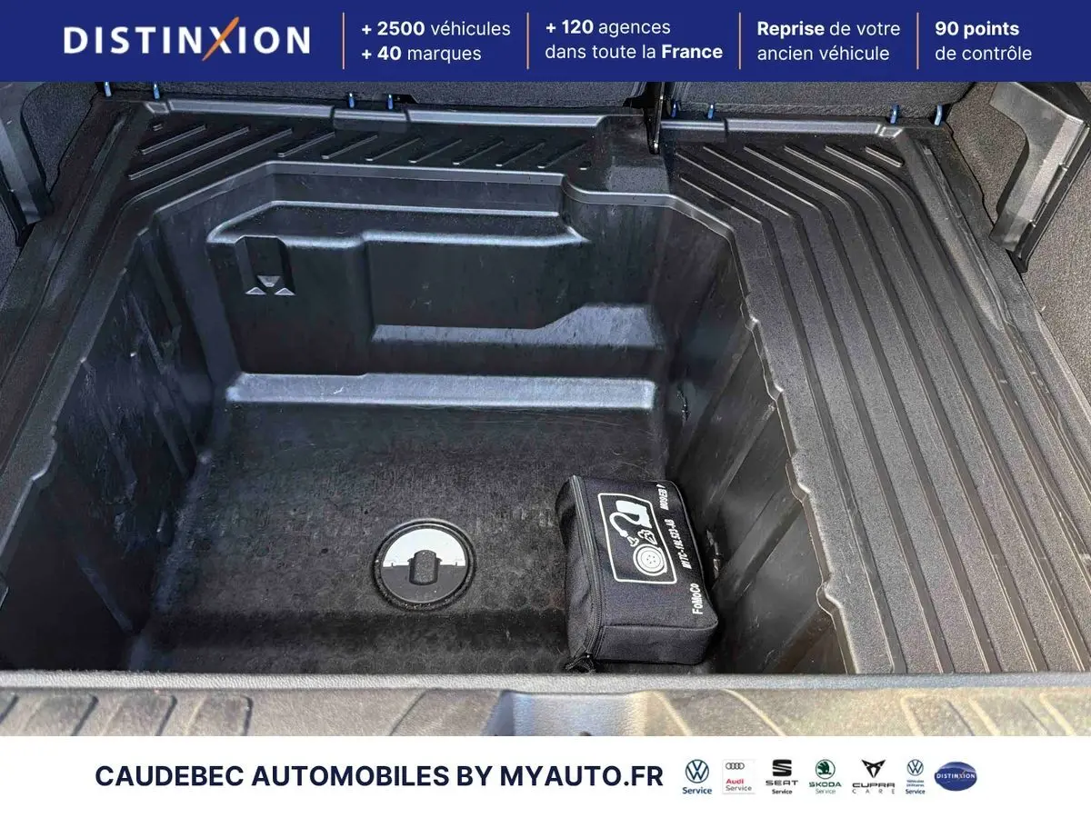 Coffre ouvert du Ford Puma bleu 2024, montrant le compartiment de rangement Megabox avec kit de réparation pneus.