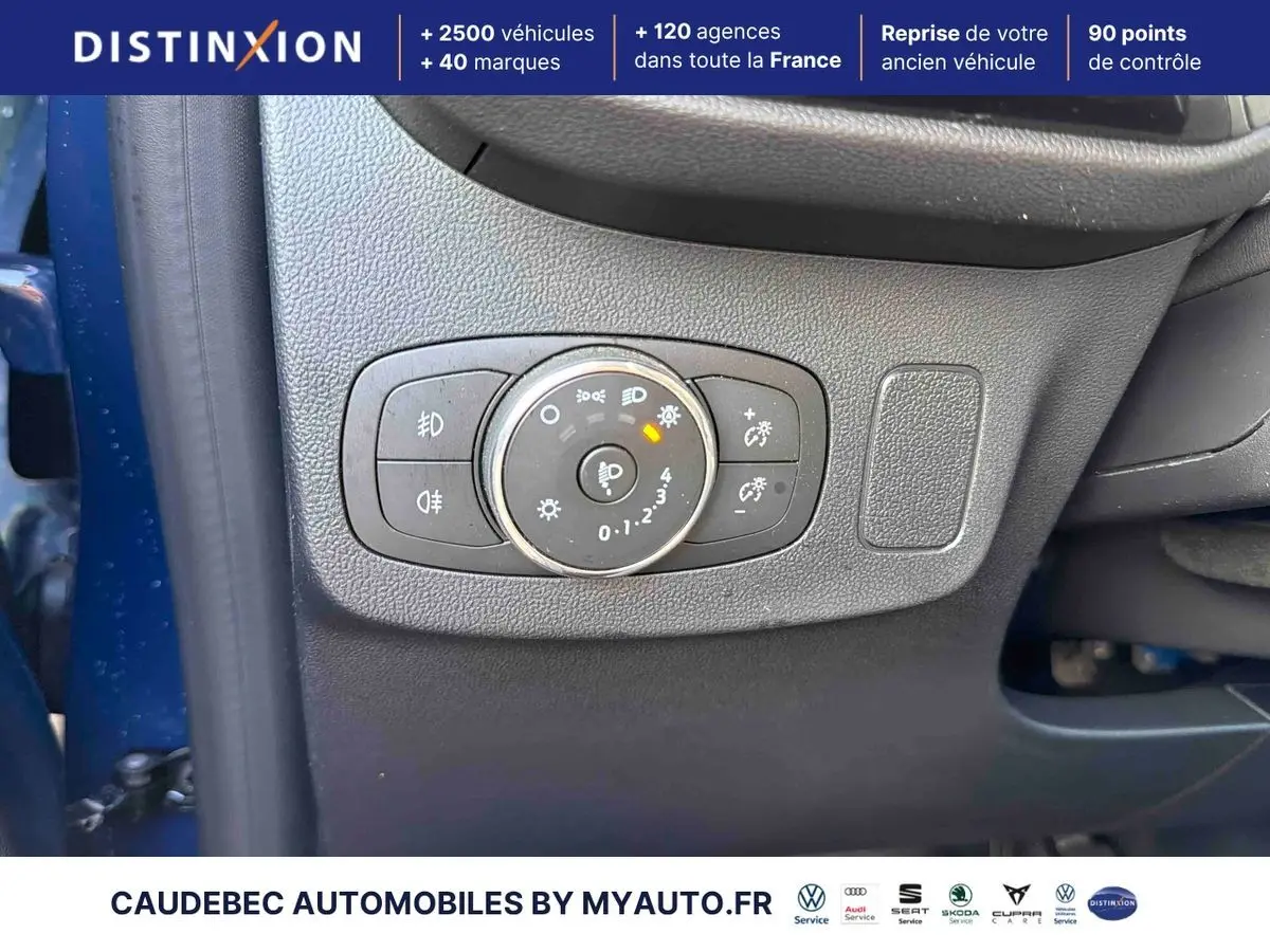 Gros plan sur le panneau de commande des phares côté gauche d'une Ford Puma bleue 2024 avec réglages lumineux.