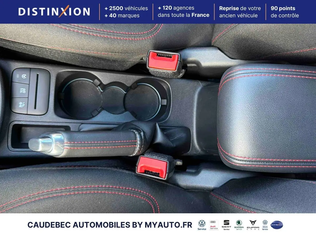 Vue plongeante sur la console centrale du Ford Puma 2024, avec frein à main et surpiqûres rouges visibles.