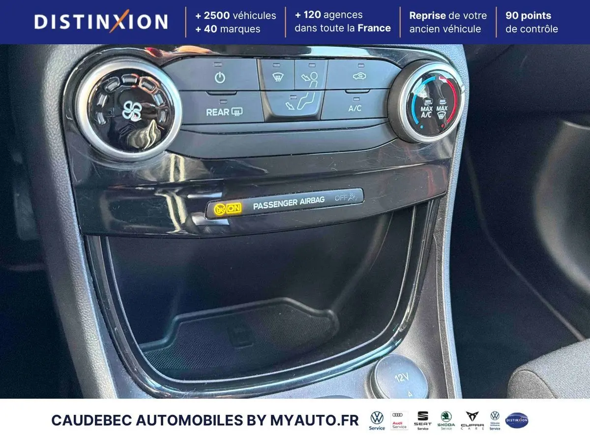 Détail de la console centrale noire avec commandes de climatisation et témoin airbag passager allumé dans Ford Puma bleu 2024.