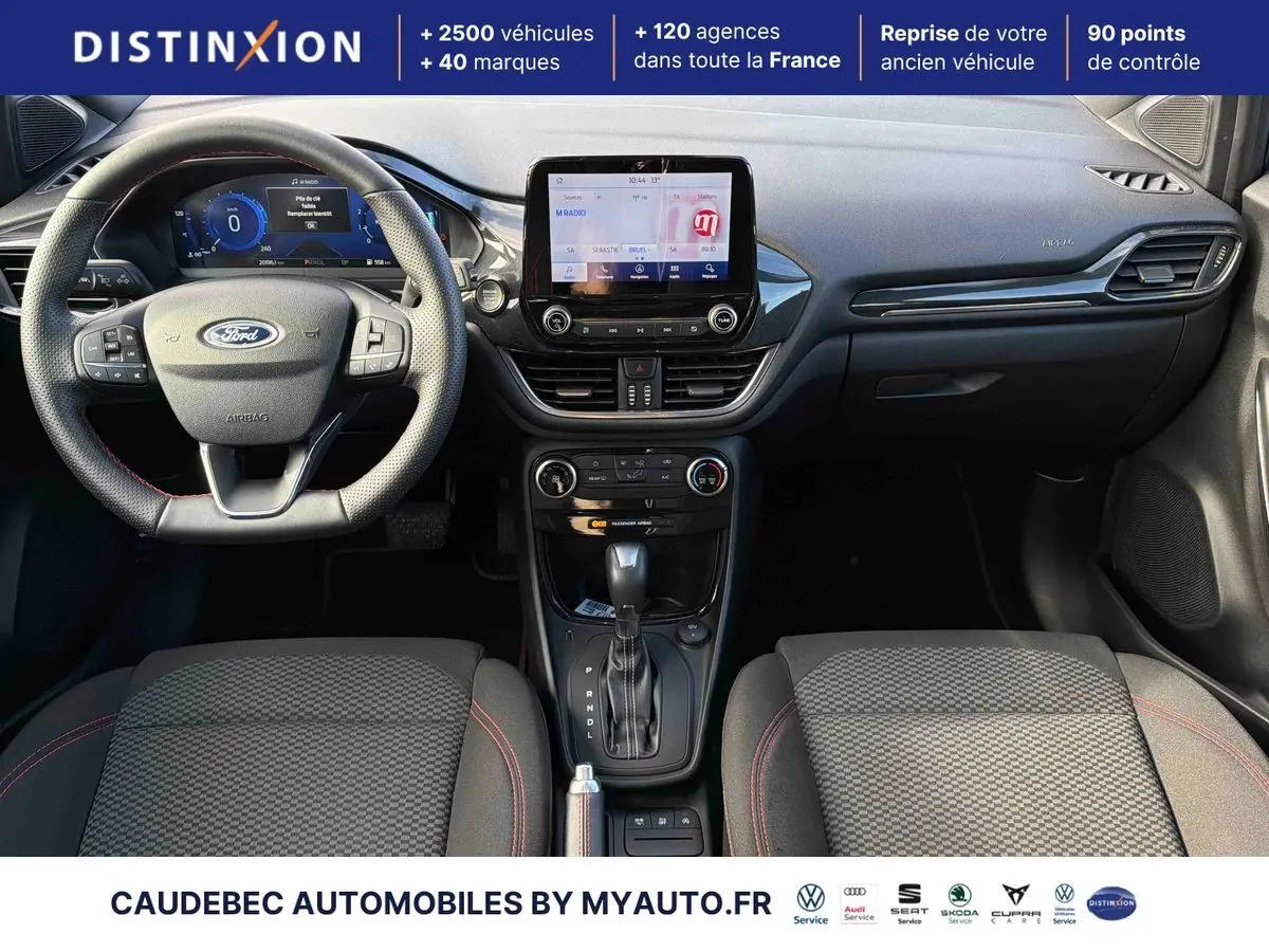 Vue intérieure avant du Ford Puma 2024 avec tableau de bord noir, écran tactile central et volant multifonction.