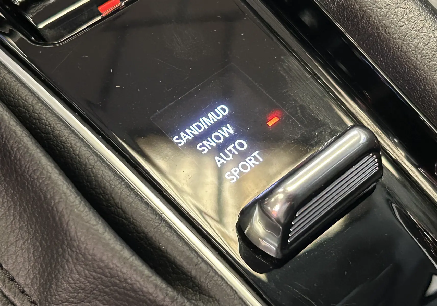 Gros plan sur la commande de modes de conduite du Jeep Compass Limited gris, avec options sable, neige, auto et sport.